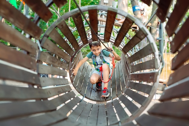 Rope Park. The kid passes the obstacle in the rope Park.