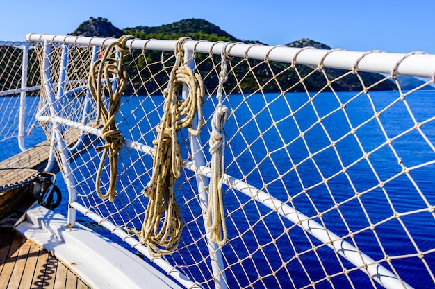 Ropes hanging on railings at the yacht bow