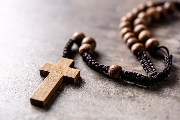 Rosary catholic cross on wooden table