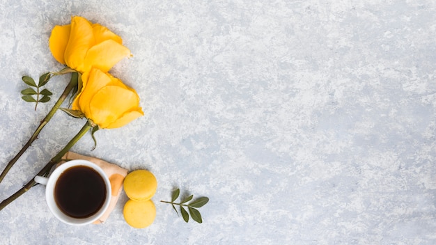 Rose flowers with macaroons and coffee cup