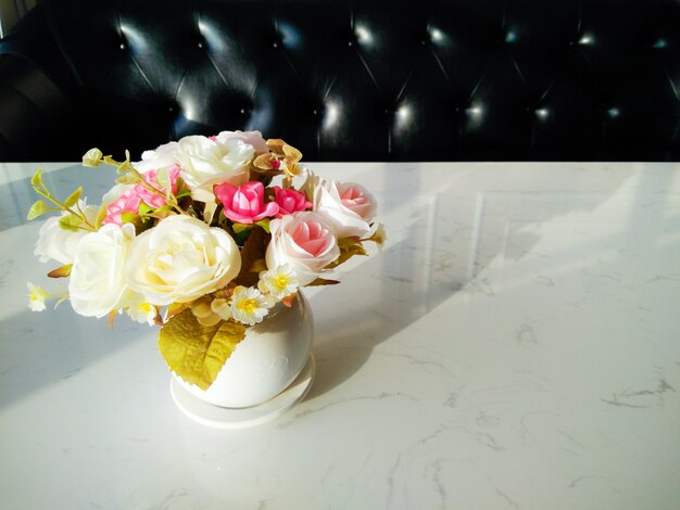 Rose in vase on white granite table with window light