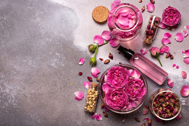 Rose water in a glass bowl with petals and fresh flowers