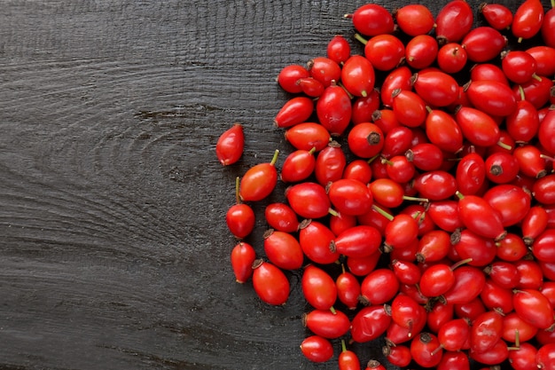 Rosehip red berries on a black wooden background