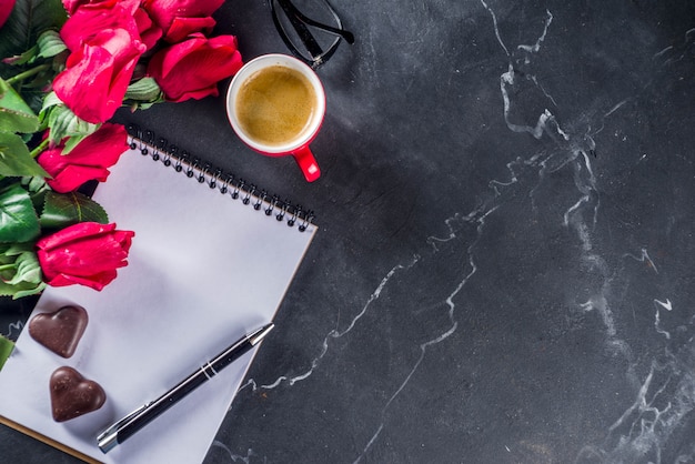 Roses, calculator, notebook and glasses on marble