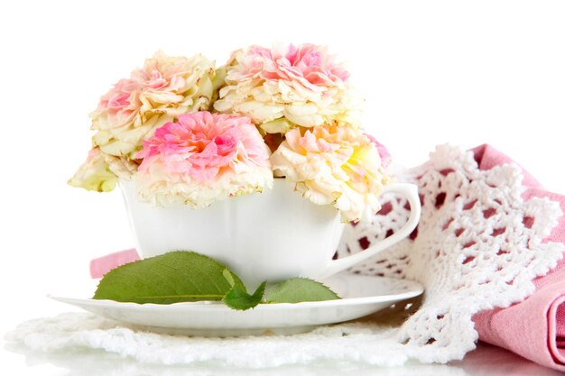 Roses in cup on napkins isolated on white