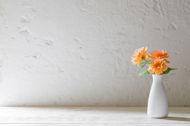 Roses in vase on background white wall