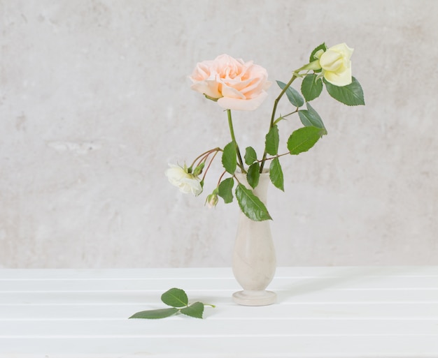 Roses in vase on old white