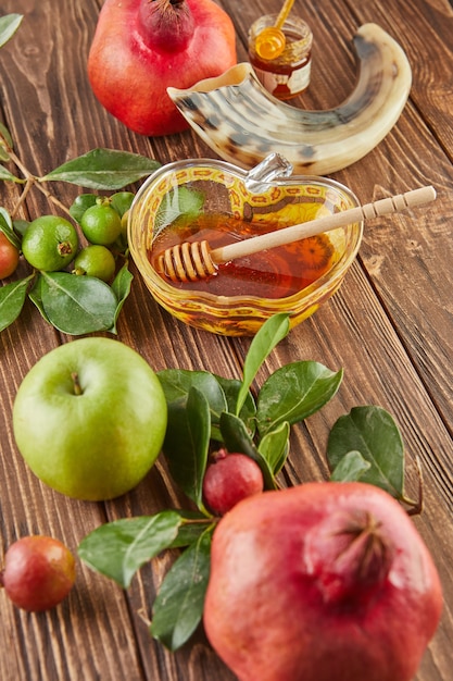 Rosh hashanah - jewish New Year holiday concept. A bowl in the shape of an apple with honey, pomegranate, shofar are traditional symbols of the holiday