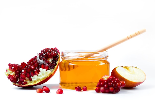 Rosh Hashanakh Jewish holiday Apples pomegranates and honey isolated on white background