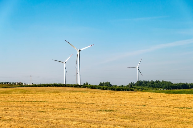 Rotating blades of a windmill propeller on blue sky background Wind power generation Pure green energy