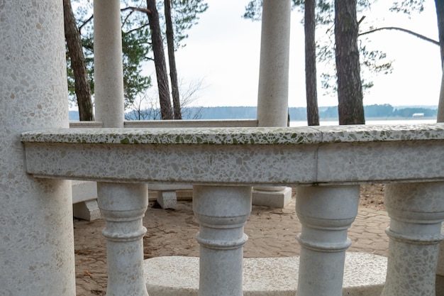 Rotunda with columns among the forest on the shore of the lake