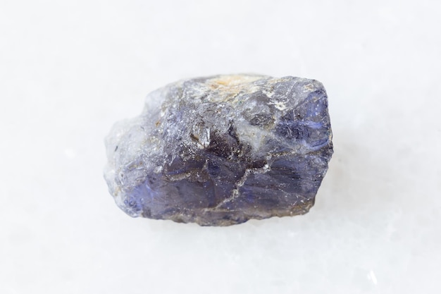 Rough Cordierite Iolite crystal on white marble