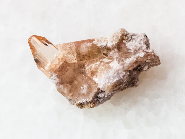 Rough crystal of topaz gemstone on white