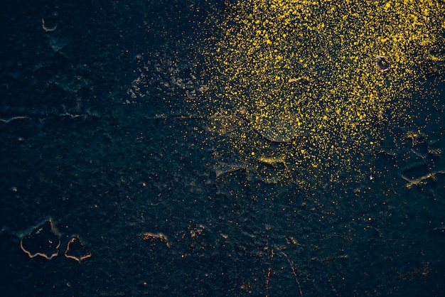 Rough dark blue wall with yellow sprays of dye