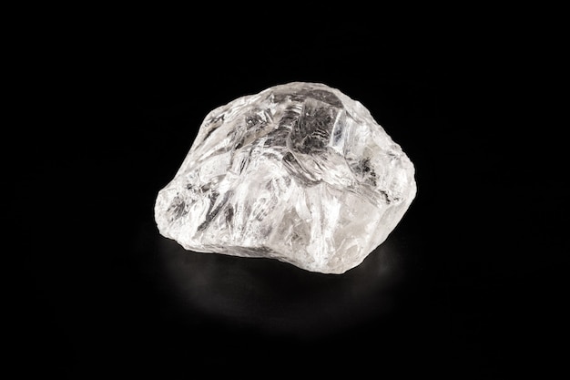 Rough diamond on isolated black background, rare and precious mineral concept.