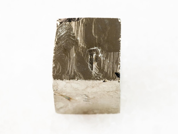 Rough pyrite crystal on white marble