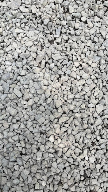 Rough texture of wall made of small gray cement pebbles Small uneven gravel texture