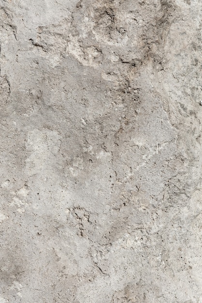 Rough, uneven texture of a gray concrete wall close up