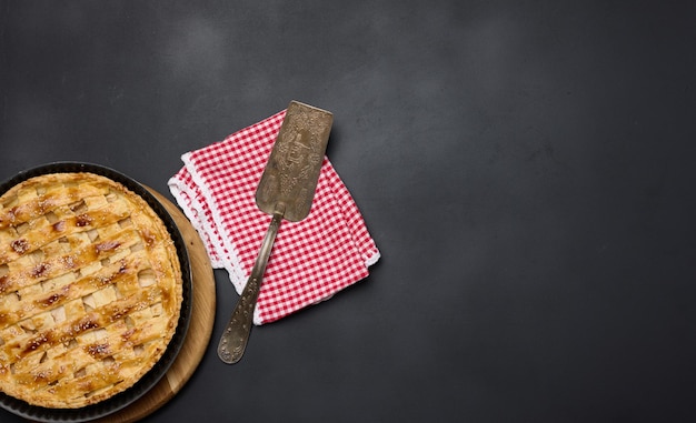 Round baked apple pie on a black table View from above