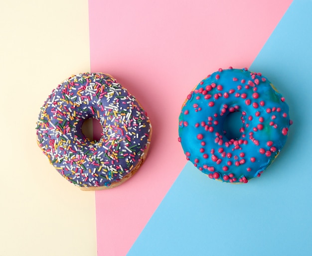 Round baked donut with colored sugar sprinkles and with blue sugar glaze