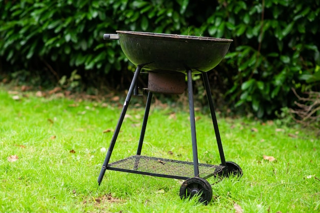 Round barbecue grill on green grass Picnic grilling concept