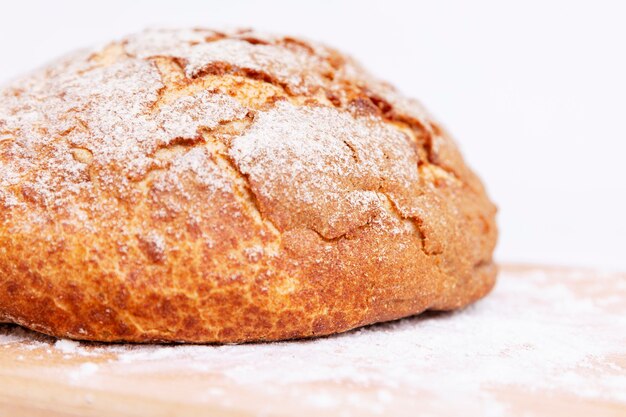 Round bread with a crispy crust on a wooden board. Close-up.