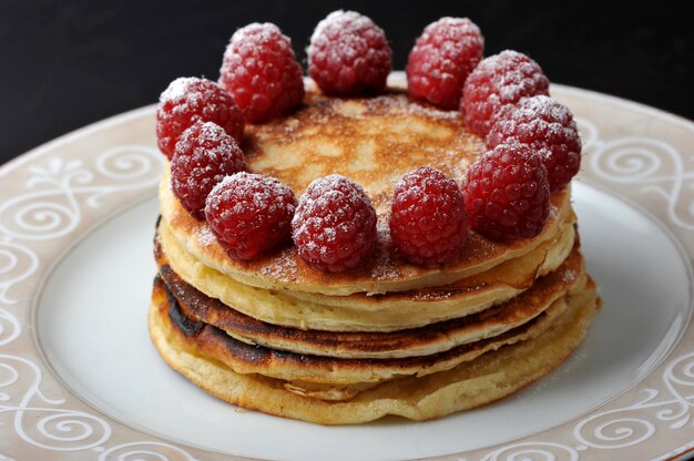 Round cake of several layers with raspberries