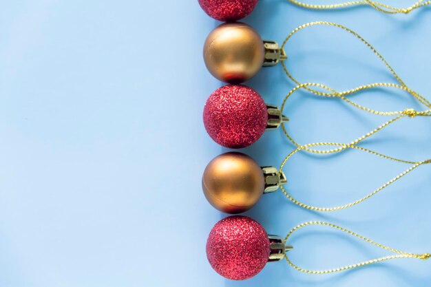 Round Christmas toys are assembled in a row and lie on a blue background with a place to copy