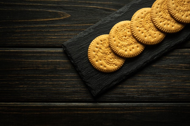 Photo round cookies on a black serving board prepared for dessert at the hotel