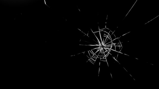 Round cracks in glass on black background. The hole in the glass surface from the bullet.