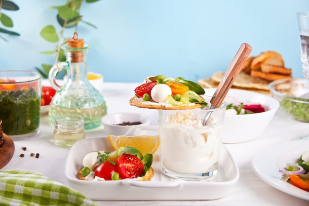 Round crispbread with greens and vegetables, fresh salads on the dinner table