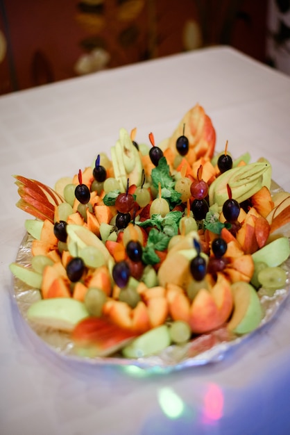 Round dish served with slices of fruits and grape