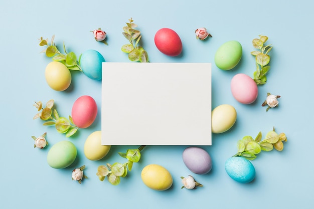 Round frame multicolored Easter eggs with white blank paper on a brown background closeup space for text blank for design selective focus tinted image