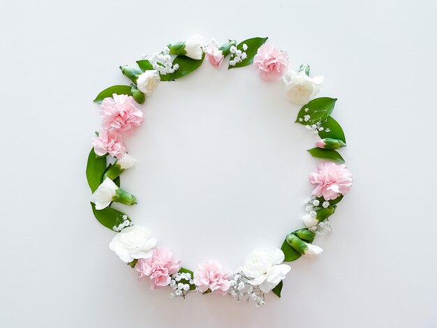 Round frame of pink and white carnations leaves