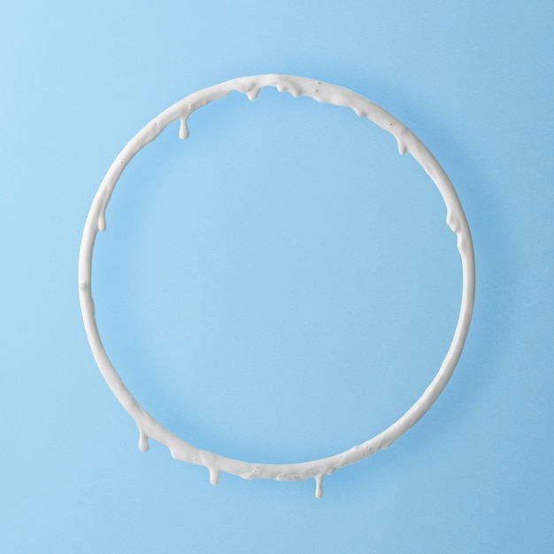 Round frame with white paint drips on a blue background Creative layout