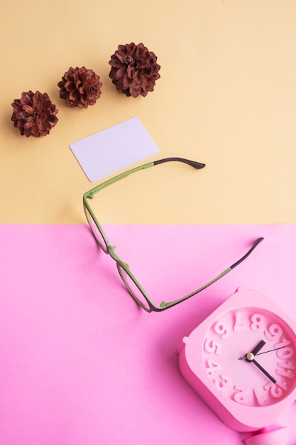 Round glasses in the photo in minimal summer style on a pastel pink and yellow background. Alarm Clock , Pine Tree Flowers , Business Cards