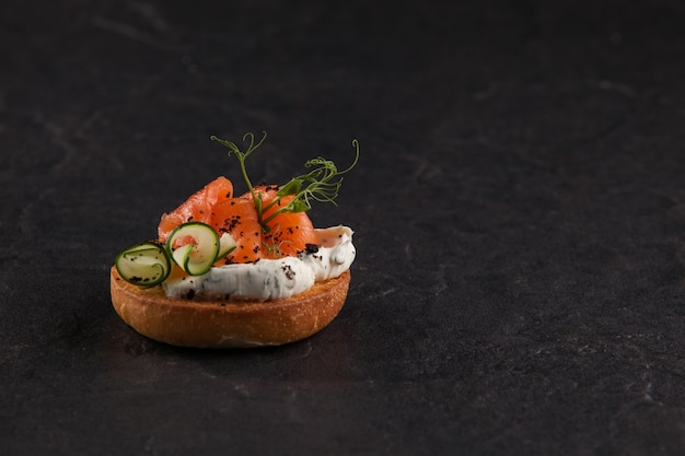 Round Italian bruschetta with fish, tomatoes, cream cheese and vegetables.