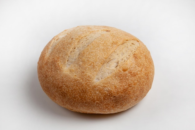 Round loaf of wheat bread on sourdough on a light background