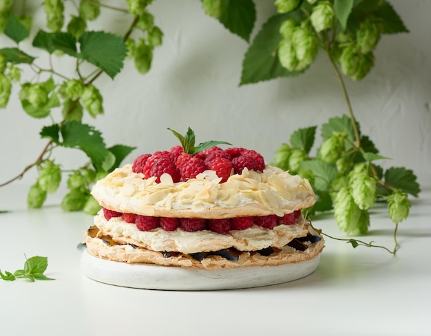 Round meringue pie with fresh raspberries on a white background Pavlova dessert