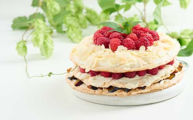 Round meringue pie with fresh raspberries on a white background Pavlova dessert