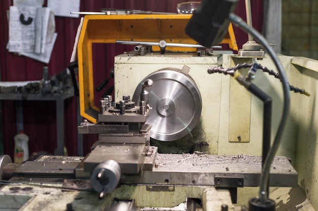 The round metal workpiece is machined on a lathe