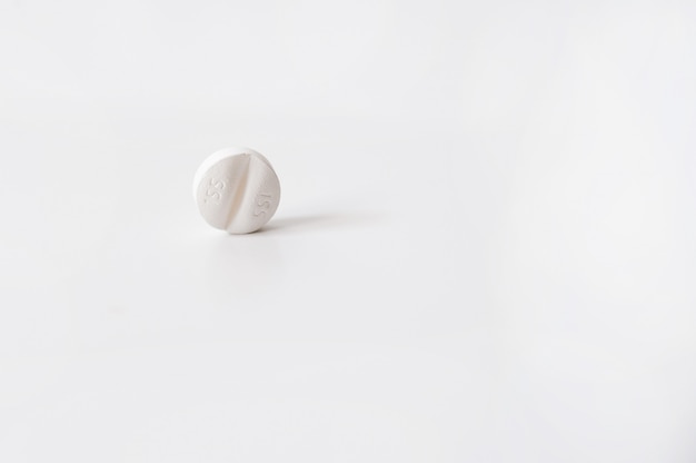 Round pill on a white background. White pill close-up 