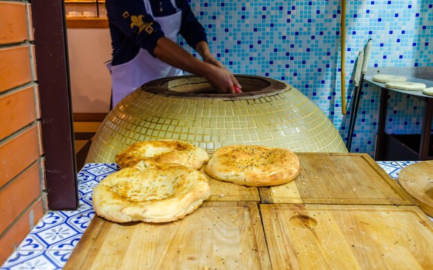 Round pita bread on the table near the oven.