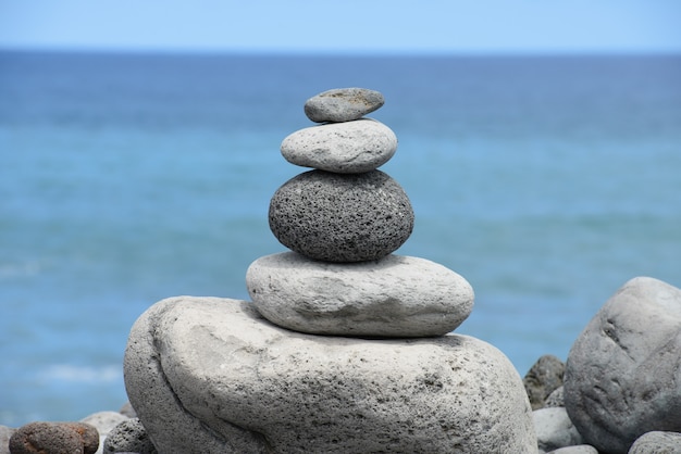 Round stones stacked pyramid on the seashore, balance concept