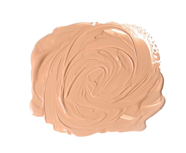 Round swatch of beige liquid concealer face cream on white isolated background, liquid is squeezed out