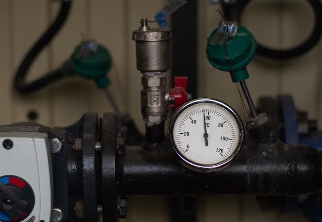 round thermometer on a pipe in the boiler room