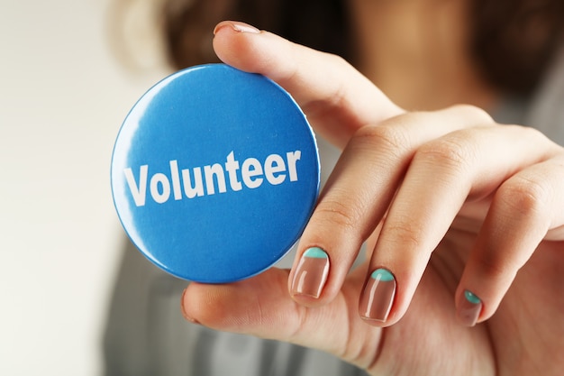 Round volunteer button in hand close-up