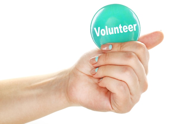 Round volunteer button in hand isolated on white