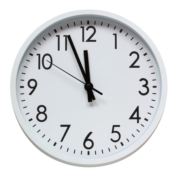 Round wall clock isolated on a white background with a clipping path twelve o'clock midnight new year time isolate white plastic clock with black numbers and hands