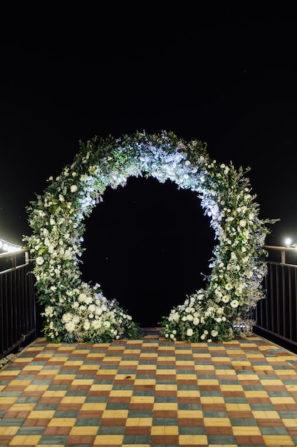 Round wedding arch decorated with fresh flowers Evening ceremony